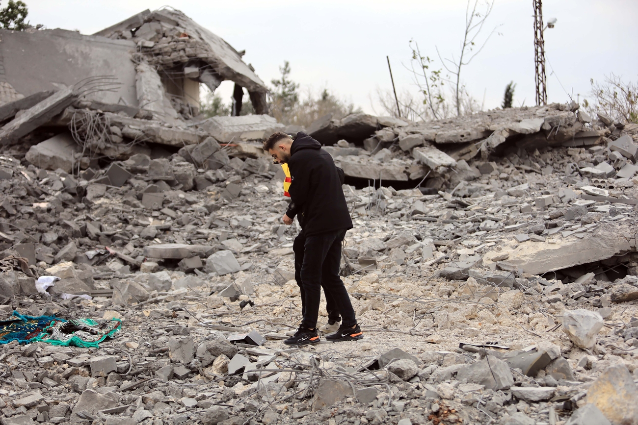 A man walks through wreckage of a destroyed home