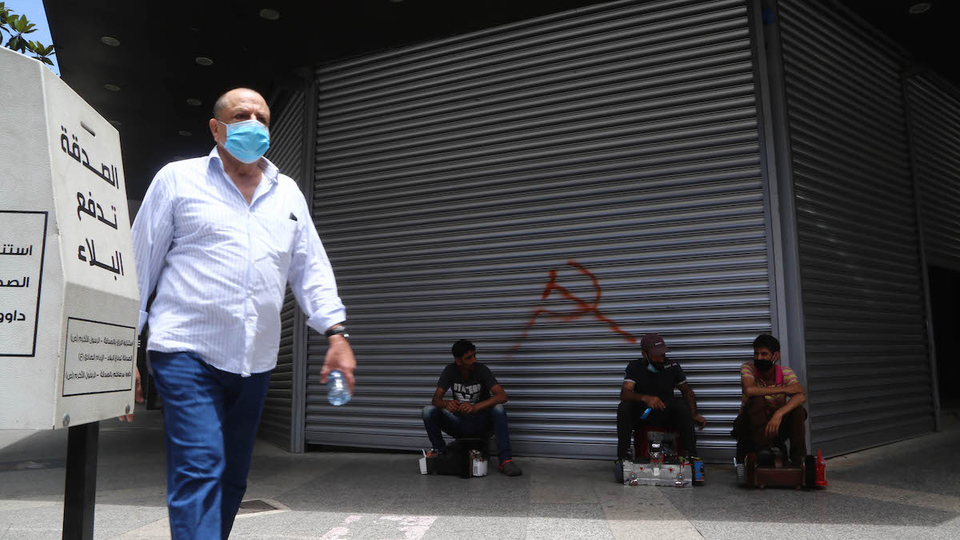 Shoeshiners rest on the street while waiting for customers. Hamra, Beirut. June 22, 2020. (Hussein Baydoun/The Public Source)