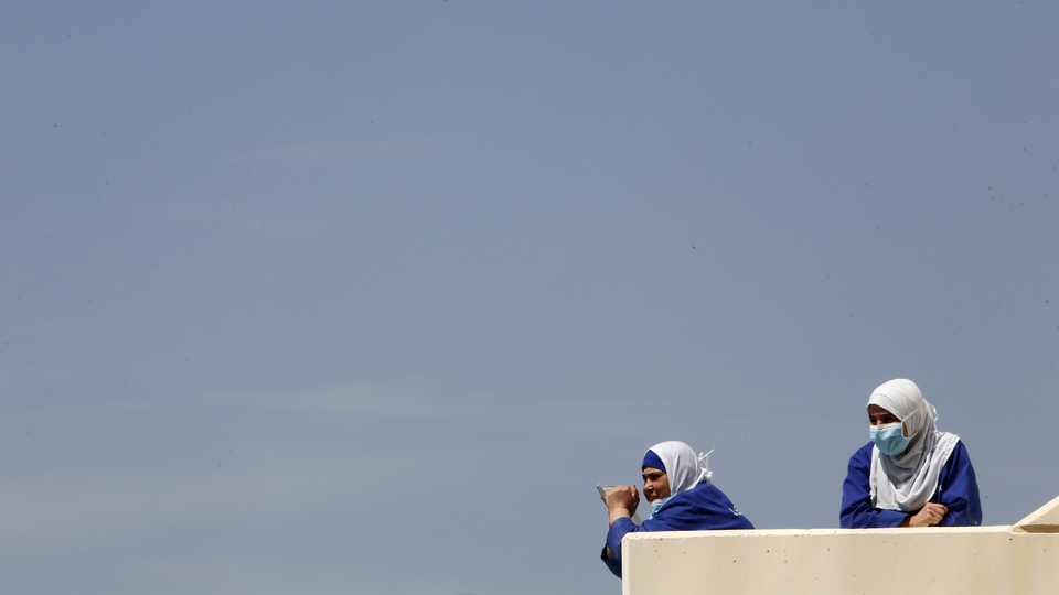 Health care workers take a break outside the Rafik Hariri University Hospital. Beirut, Lebanon. April 17, 2020. (Marwan Tahtah/The Public Source)