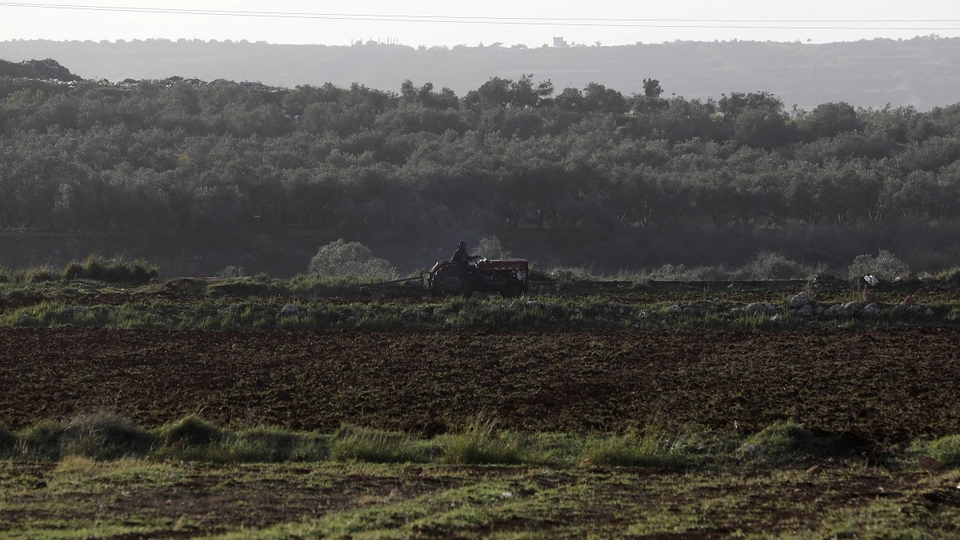 Farmer uses his tractor to till the green land in Akkar